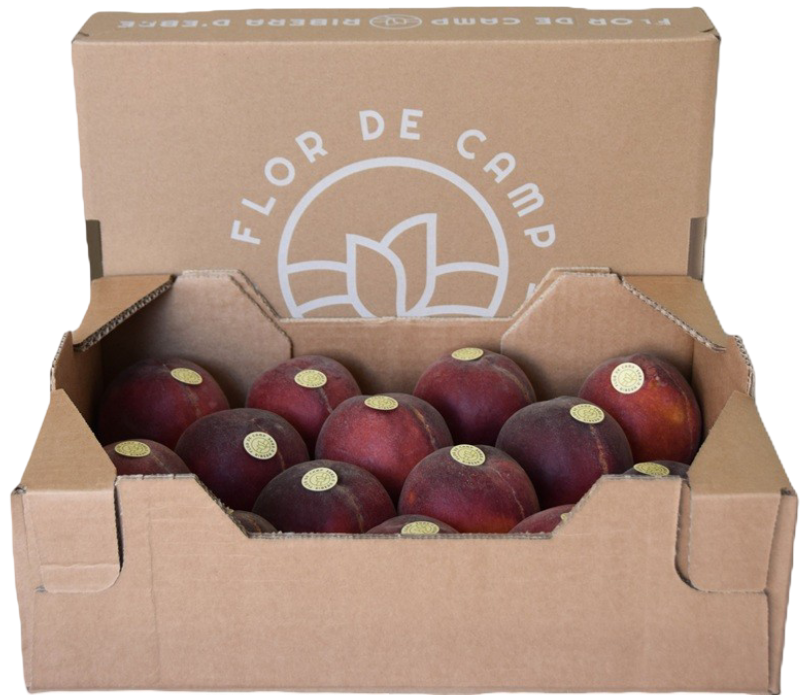 Fotografia d'una caixa de préssecs rojos amb l'etiqueta de Flor de Camp, Ribera d'Ebre.